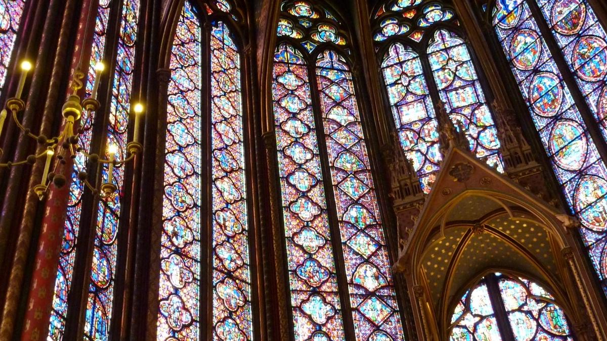 looking up to a large cathedral ceiling supported by swaths of stained glass