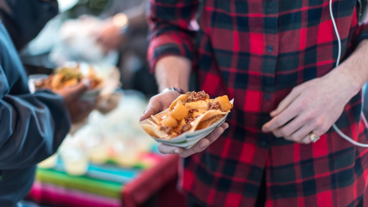 a close up photo of a student holding a boat of nachos